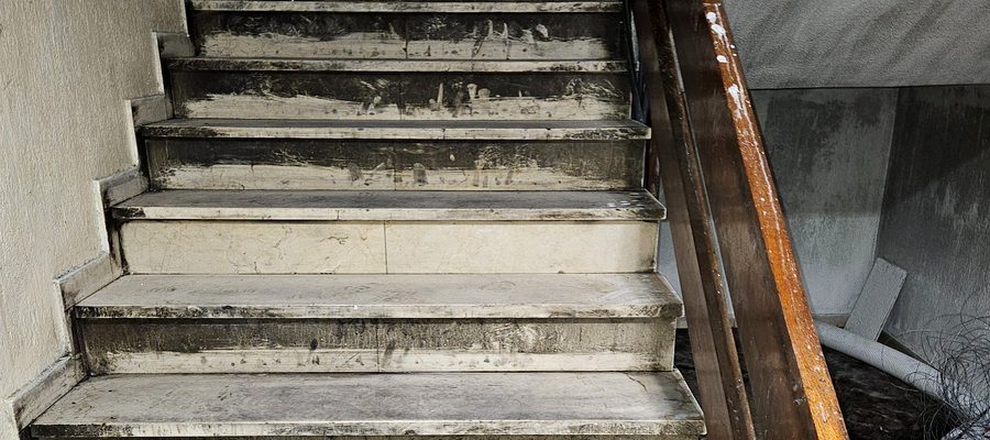 Escaleras de edificio cubiertas de hollín y ceniza tras incendio