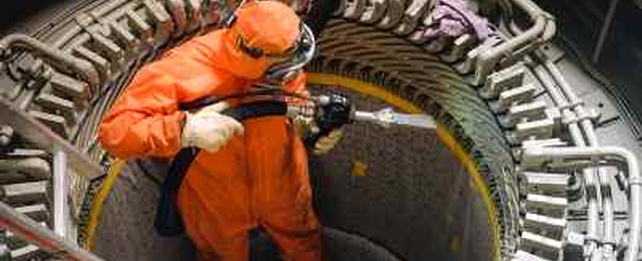 Técnico con EPI completo aplicando limpieza criogénica con hielo seco en turbina industrial