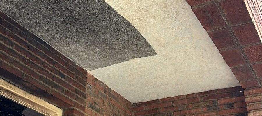 Máquina láser actuando en techo de ladrillo afectado por hollín de incendio