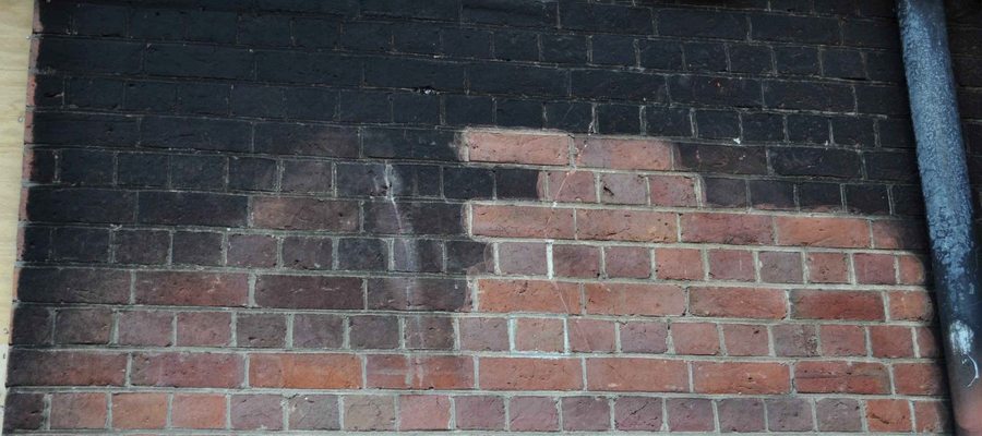 Antes y después de limpieza láser en muro de ladrillo — hollín eliminado completamente